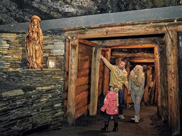 Eine Familie betrachtet eine Statue in der Barbara Grotte, ein Ausflug vom Hotel Oberhof.