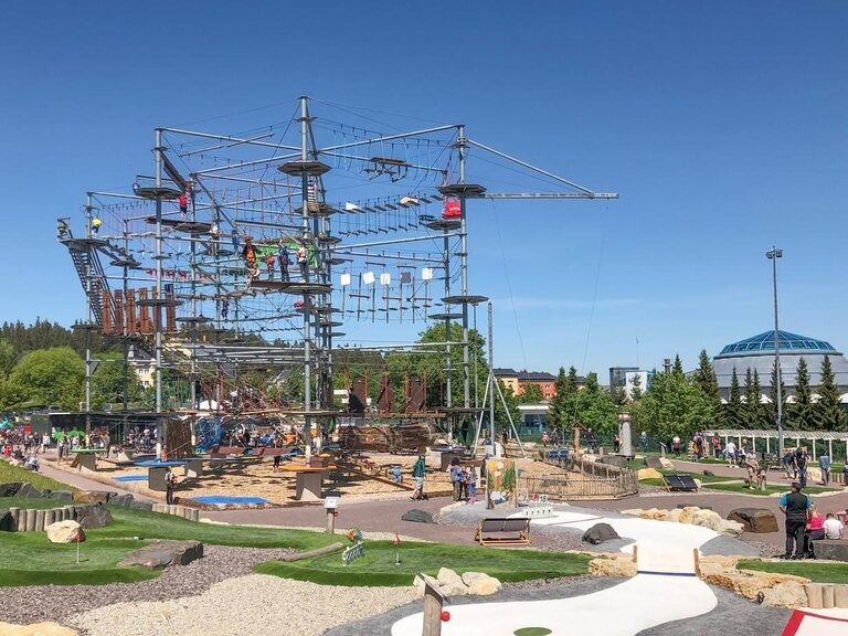 Blick auf den Kletterturm und die Golfanlage, im Hintergrund steht das H2Oberhof.