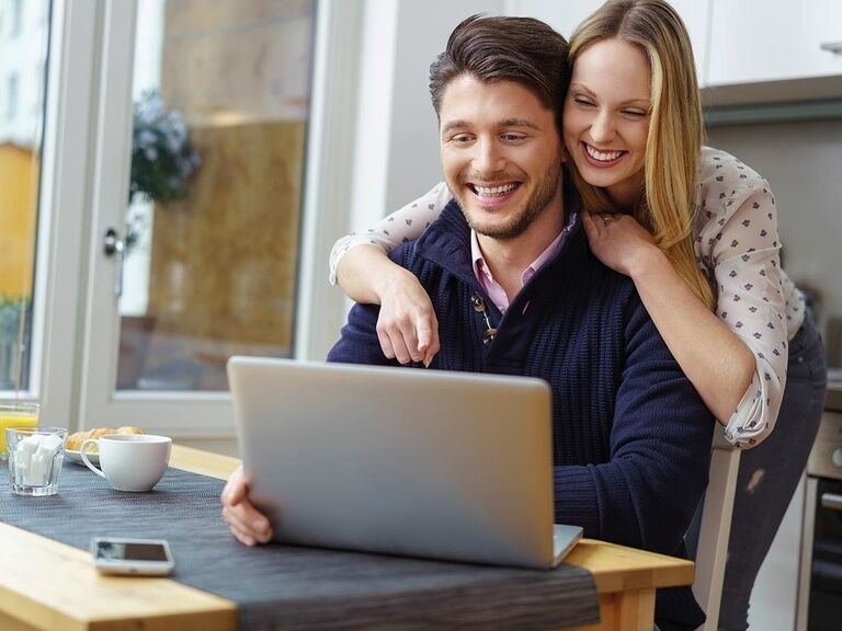 Couple looking at PC, brochures Oberhof hotel (icon image)