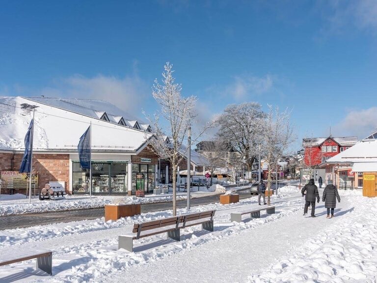 Fußgänger flanieren durch das winterliche Zentrum Oberhofs.