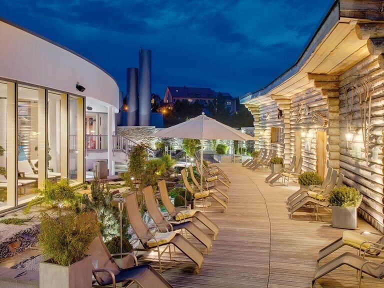 Ein wunderschöner Garten mit Ruheliegen am Abend.