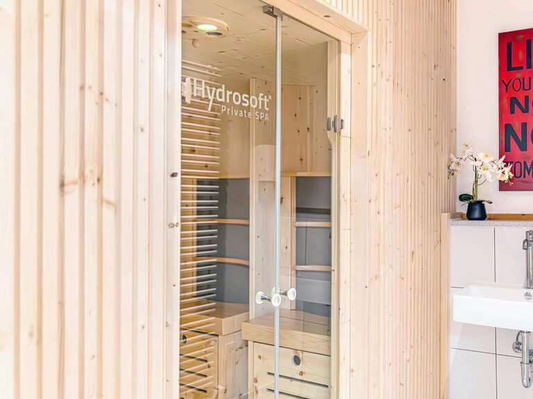 Liebevoll gestalteter Eingangsbereich zur holzverkleideten Hydrosoft-Infrarotkabine.
