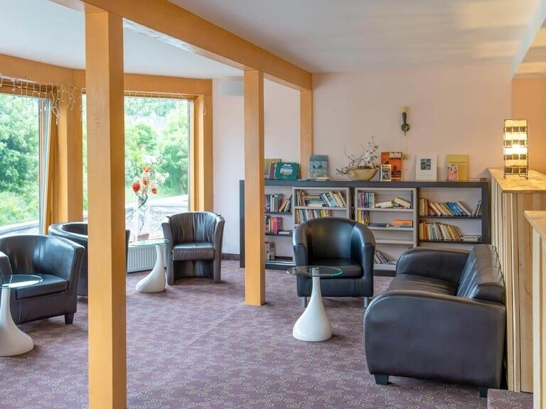 The bright and spacious library of the Schlossberghotel invites you to linger and relax.