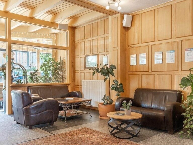 Bequeme Ledermöbel und Couchtische stehen im Eingangsbereich des Schlossberghotels.