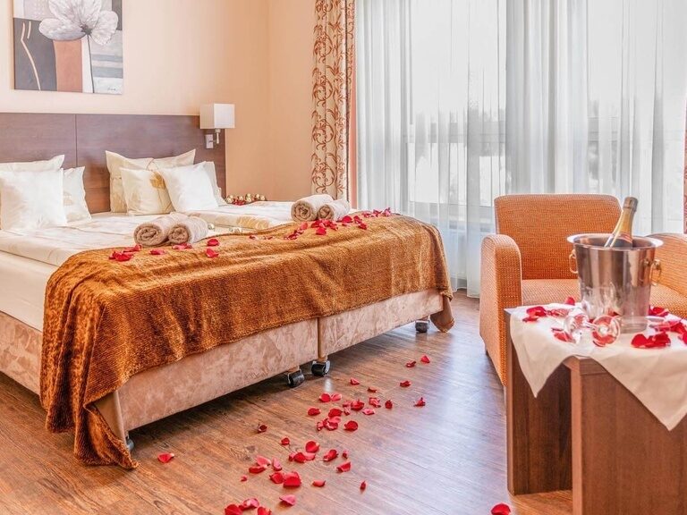 Blütenblätter, Kerzen, Handtuch-Herzen und gekühlter Champagner auf dem Zimmer.