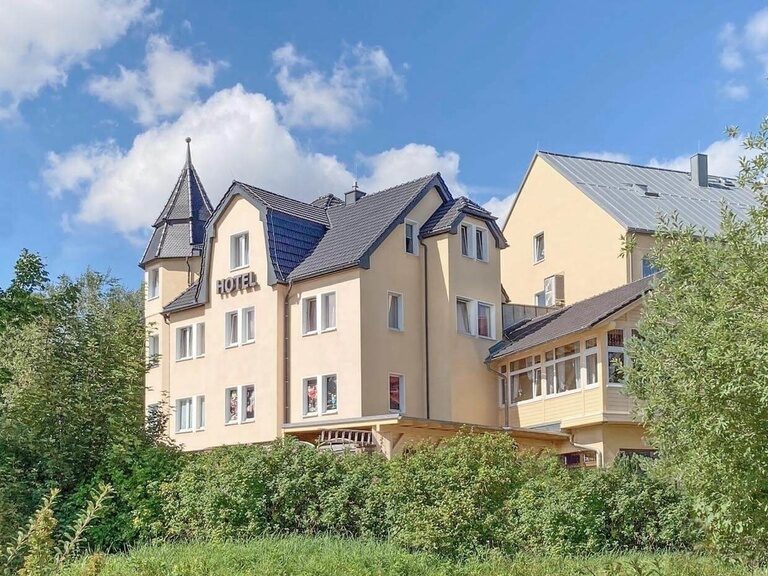 Blick vom H2Oberhof Wellness & Erlebnisbad zum Wintergarten des Hotels.