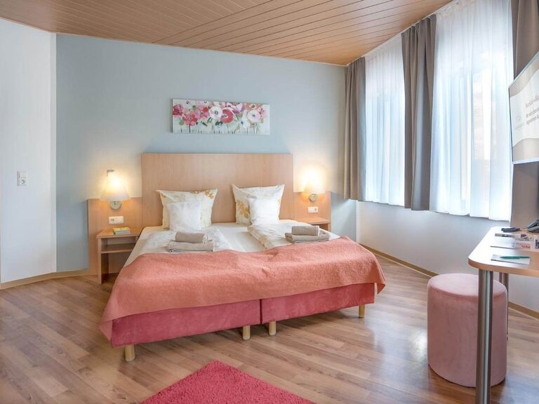 Großes Doppelbett im gemütlichen Economy Zimmer im historischen Teil des Hotels.