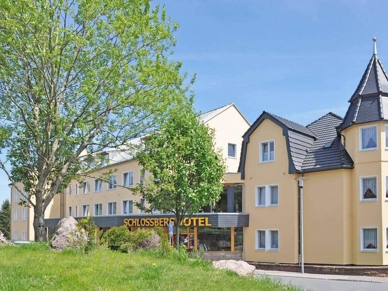 Das Türmchen und der Haupteingang strahlen bei sommerlichen Wetter.