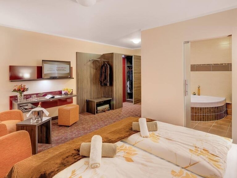 Blick über das Bett zur Milchglas-Schiebetür des Badezimmers.