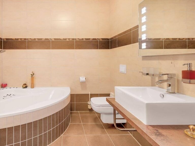 Modernes Badezimmer in Erdtönen mit Eckbadewanne.