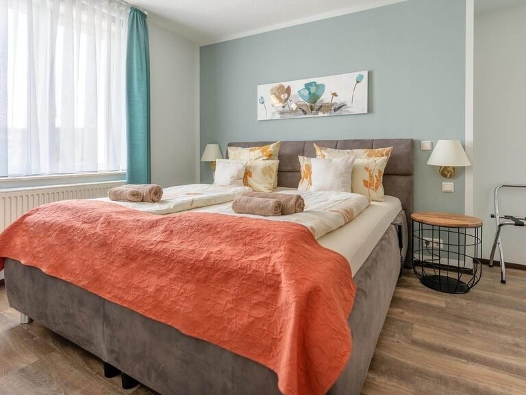 Im separaten und modernen Schlafzimmer befindet sich ein großes Doppelbett.