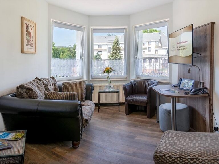 Im Wohnraum befindet sich ein großes Ledersofa, ein Flachbild-TV sowie ein Tablet.