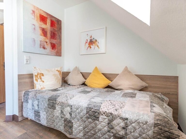 Gemütliches Einzelbett in heller Nische im Wohnzimmer.